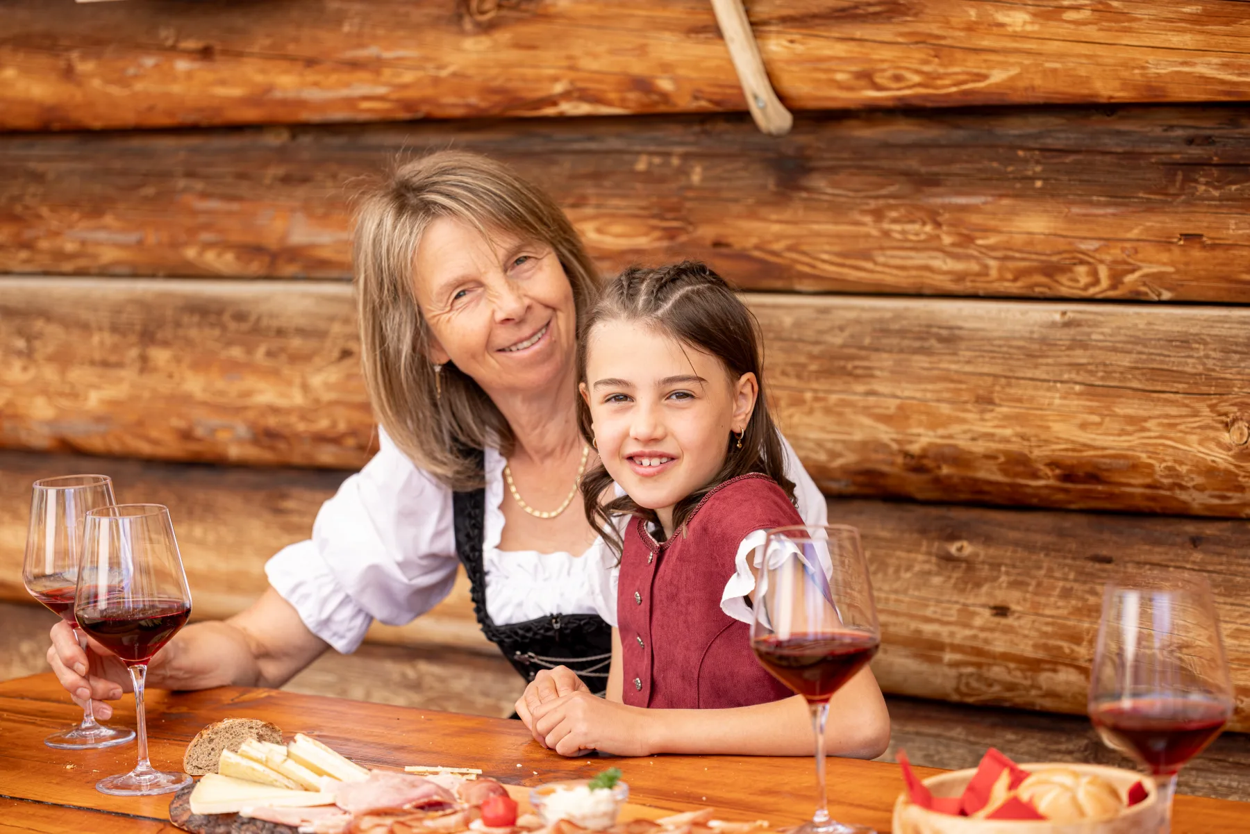 Großmutter und Enkelin bei Rotwein und Brettljause