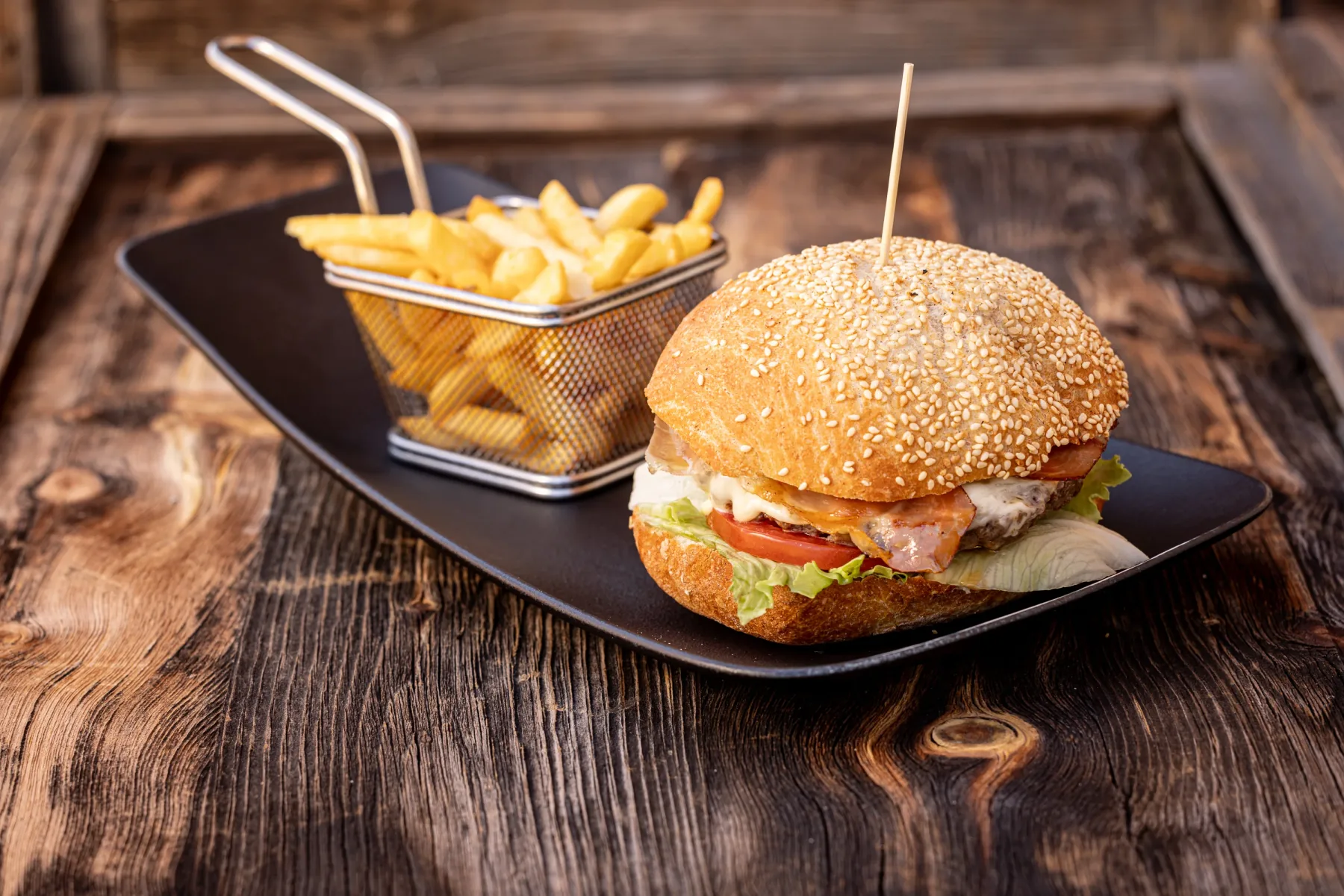 Hamburger con patatine su tagliere di legno