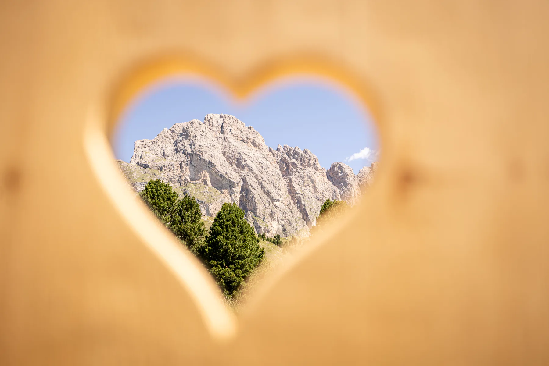 Blick durch das Holzherz auf die Dolomiten