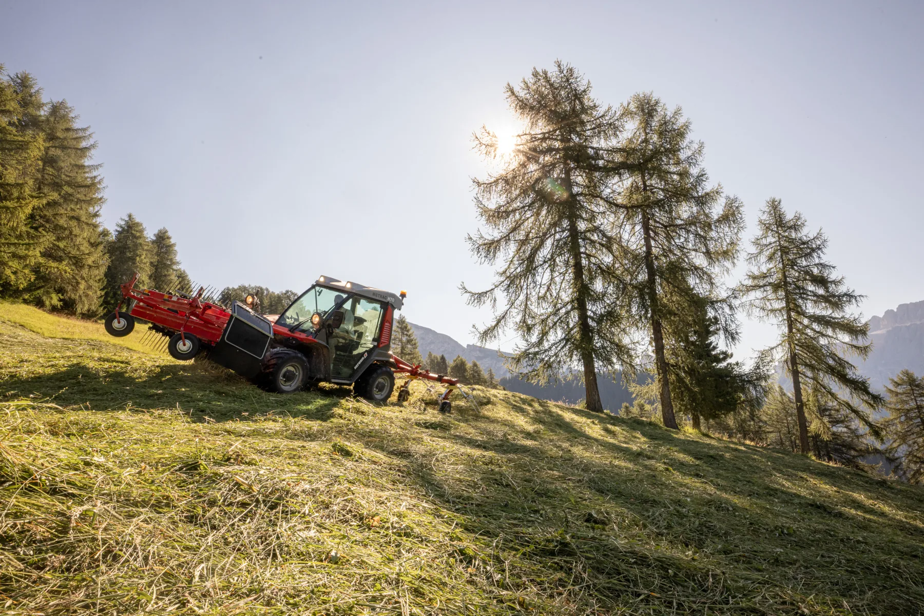 Fienagione con trattore sul prato di montagna
