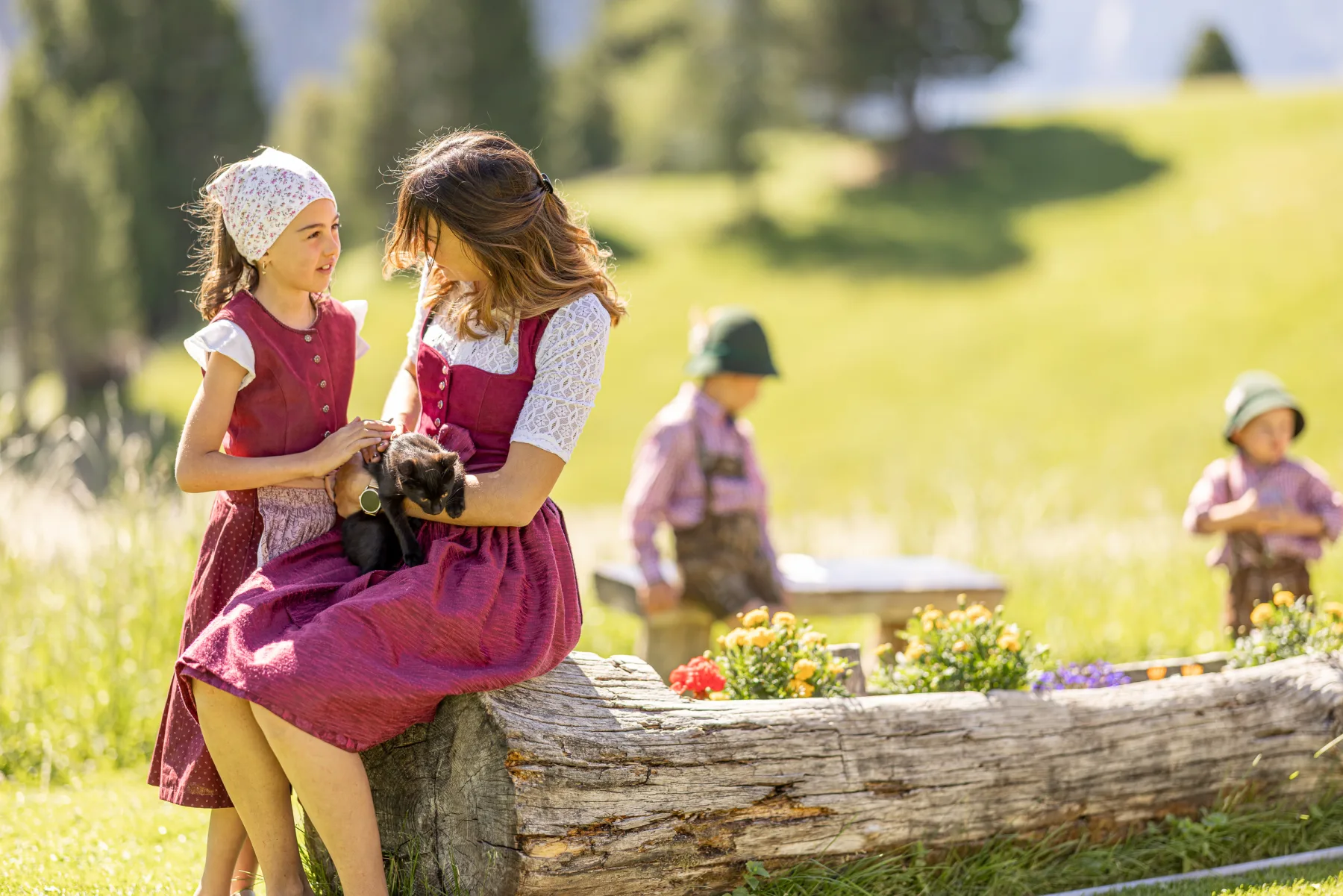 Mutter und Tochter streicheln ein schwarzes Kätzchen