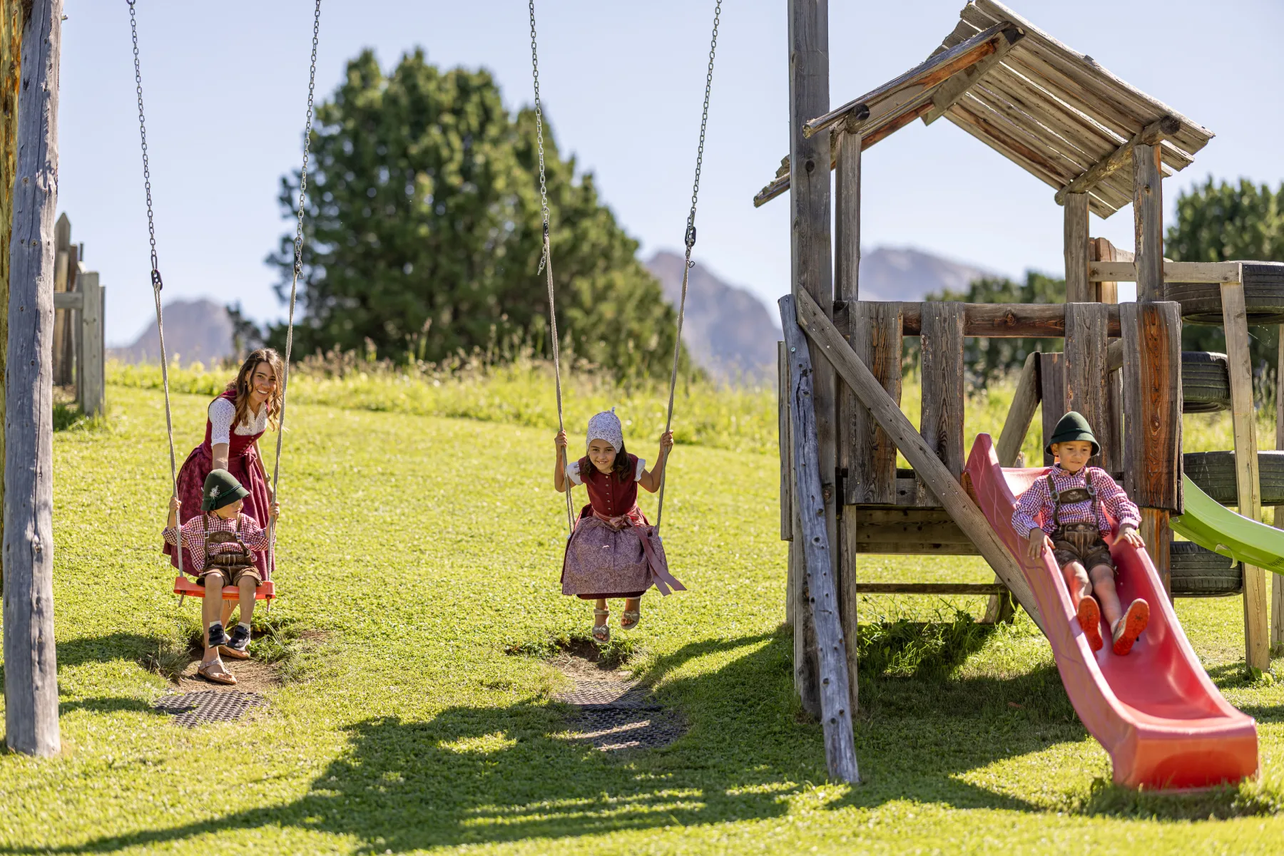 Kinder in Tracht am Spielplatz der Baita Odles