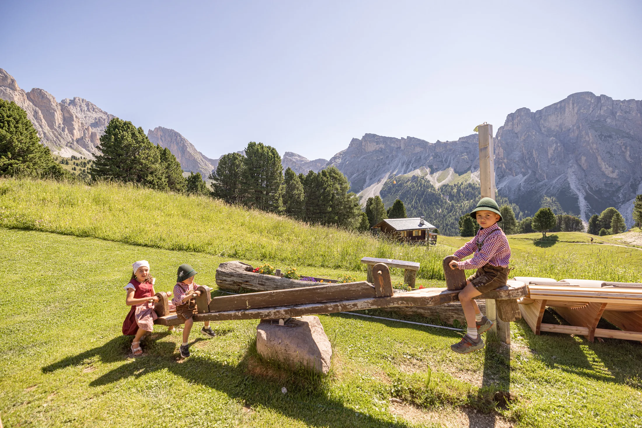 Bambini sull’altalena di legno davanti alle montagne