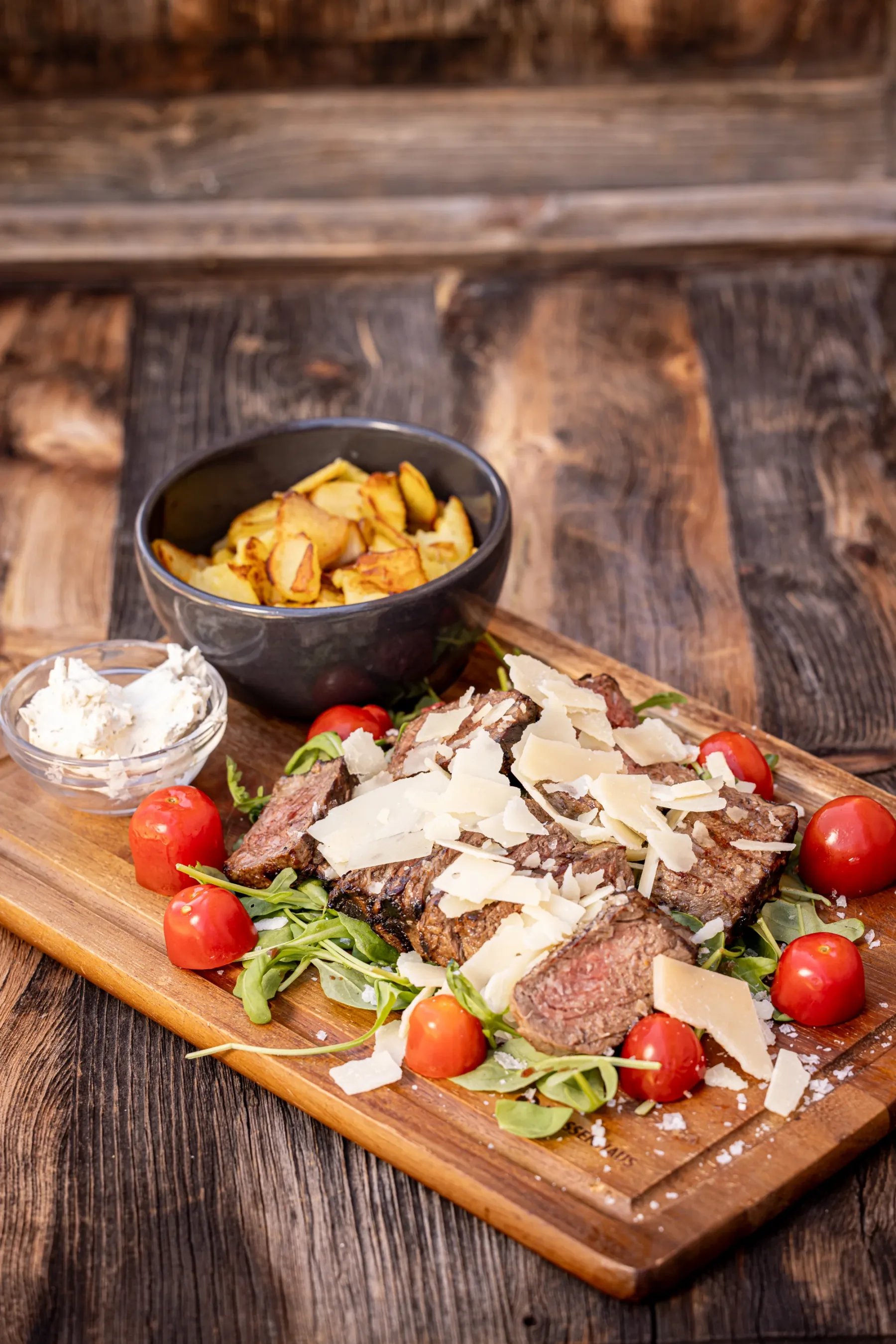 Tagliata di manzo del nostro maso con rucola, parmigiano e patate arrosto
